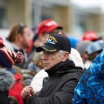 man in black jacket wearing blue cap
