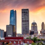 city skyline under orange and blue sky during sunset